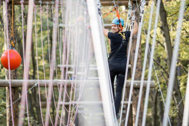 İp parkında ip tırmanan bir adam.