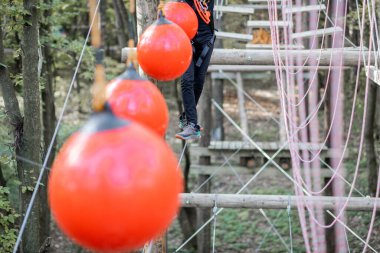 Kadın ve erkek parktaki iplere tırmanıyor.