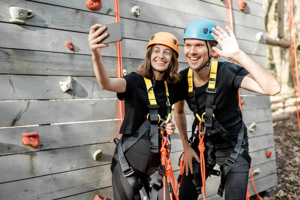 Man and woman taking selfie photo near the climbing wall