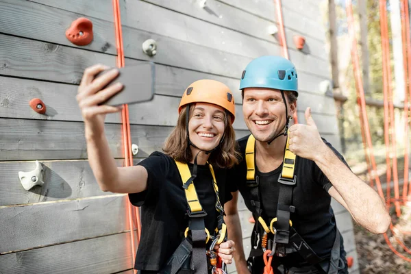 Homme et femme prenant des photos selfie près du mur d'escalade — Photo