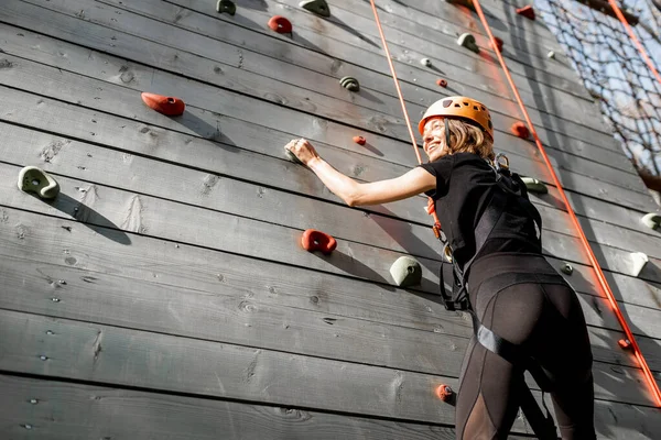 Woman climbing the wall in the park