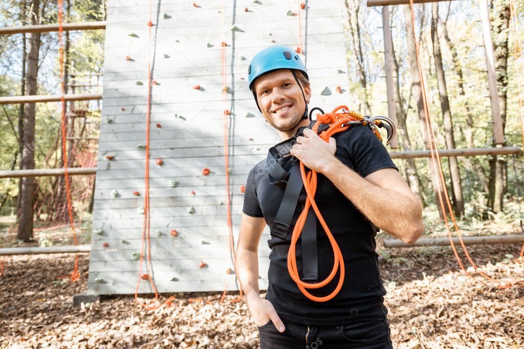 Well equipped man near the climbing wall outdoors