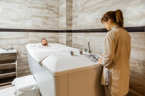 Man with a doctor at balneology room with carbon dioxide bath — Stock Photo, Image