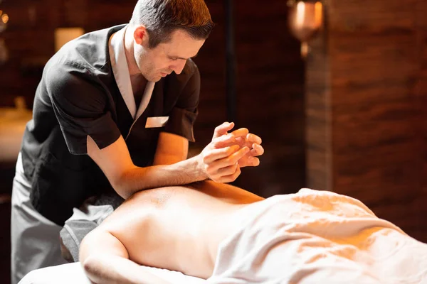 Masör bir erkek müşteriye derin bir masaj yapıyor. — Stok fotoğraf