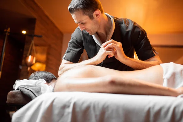 Masseur doing a deep massage to a male client — Stock Photo, Image