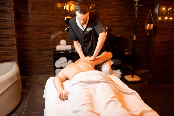 Masseur doing a deep massage to a male client — Stock Photo, Image