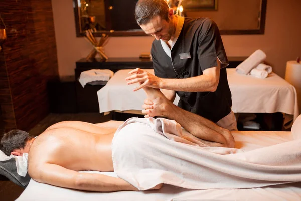 Masseur doing a deep massage to a male client — Stock Photo, Image