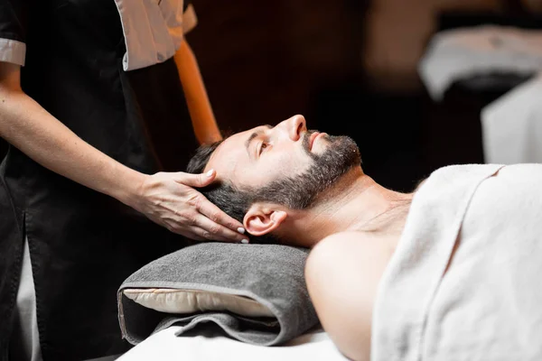 Spa salonunda yüz masajı yaptıran adam. — Stok fotoğraf