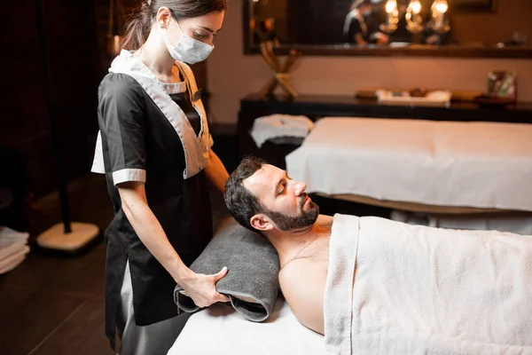 Female masseur doing facial massage to a male client — Stock Photo, Image