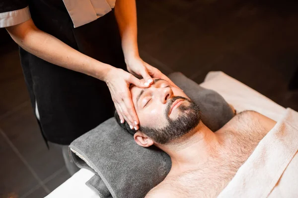 Hombre recibiendo masaje facial en el salón de Spa —  Fotos de Stock