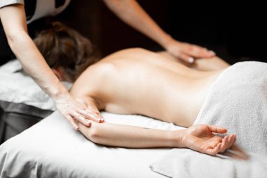 Masör bayan bir müşteriye sırt masajı yapıyor.