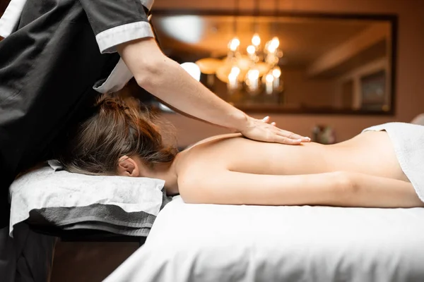 Masseur doing back massage to a female client — Stock Photo, Image