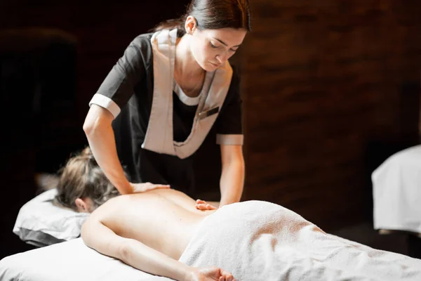 Masseur doing back massage to a female client — Stock Photo, Image