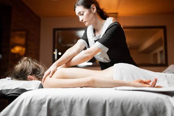 Masseur doing back massage to a female client — Stock Photo, Image