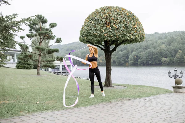 Mujer practicando gimnasia rítmica al aire libre — Foto de Stock