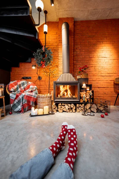 Woman in Christmas socks by the fireplace