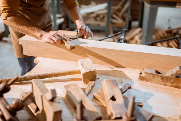 Carpenter working with a wood indoors — Stock Photo, Image