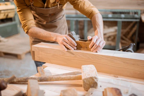 Falegname che lavora con un legno in officina — Foto Stock