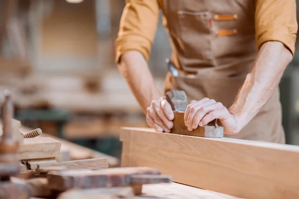 Falegname che lavora con un legno in officina — Foto Stock