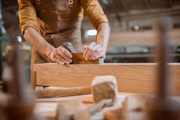 Carpenter working with a wood in the workshop — Stock Photo, Image