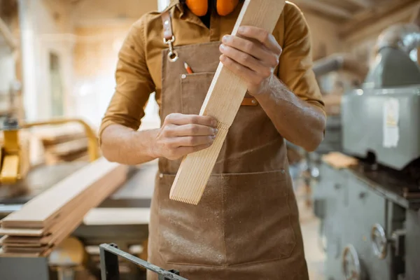 Carpinteiro trabalhando com barras de madeira — Fotografia de Stock