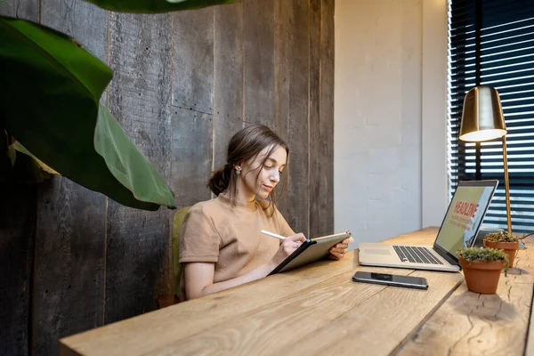 Творческая женщина с цифровым планшетом в домашнем офисе — стоковое фото