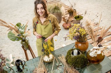 Çiçek kompozisyonları yapan bir kadın