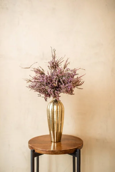 Gedroogde Calluna bloem in een gouden vaas — Stockfoto