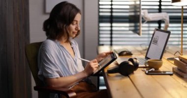 Merkez ofiste dijital tablet üzerinde çalışan bir kadın.