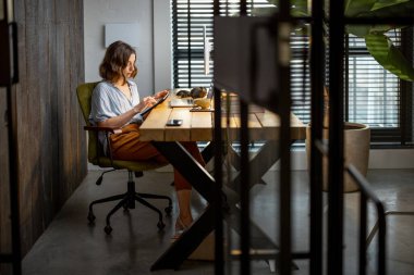 Ofisinde dijital tableti olan yaratıcı bir kadın.