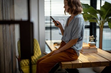Ofis işinden sonra telefonu olan kadın dinleniyor.