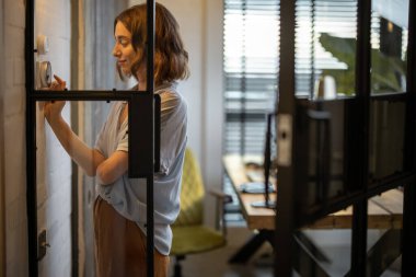 Sıcaklığı evde termostatla kontrol eden kadın