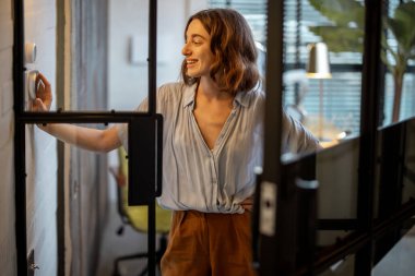 Sıcaklığı evde termostatla kontrol eden kadın