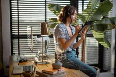 Ofiste dijital tablet üzerinde çalışan bir kadın.