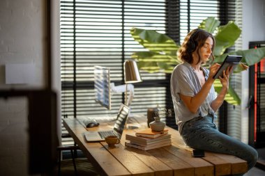 Ofiste dijital tablet üzerinde çalışan bir kadın.