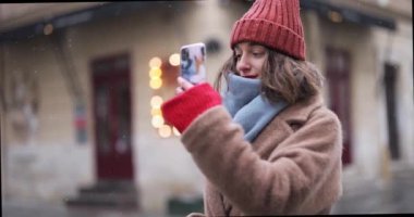 Kışın eski şehirde telefonu olan bir kadın.