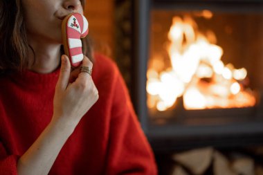 Kış tatilinde şöminenin yanında şekerli bir kadın.