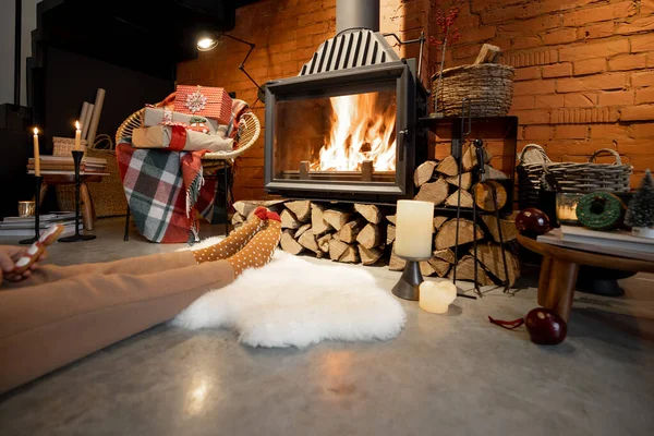 Mulher deitada ao lado da lareira em chamas em umas férias de inverno — Fotografia de Stock