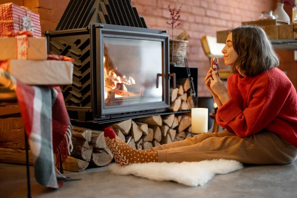 Mulher com doces na lareira durante umas férias de inverno — Fotografia de Stock