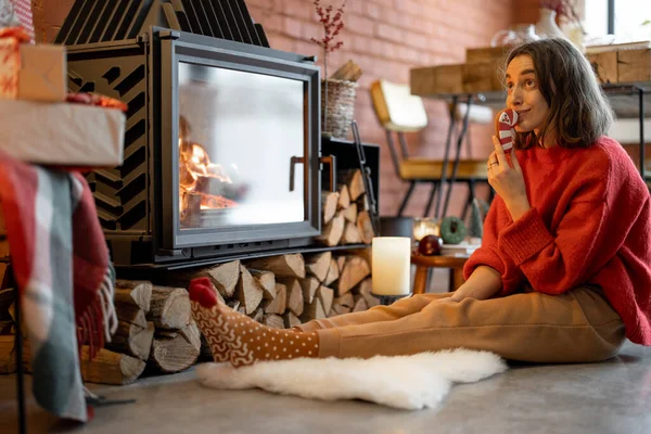 Woman with candy by the fireplace during a winter holidays — Stock Photo, Image