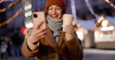Noel pazarında telefonla konuşan kadın.