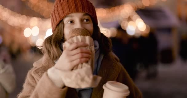 Woman with food at Christmas market at night — Stock Video