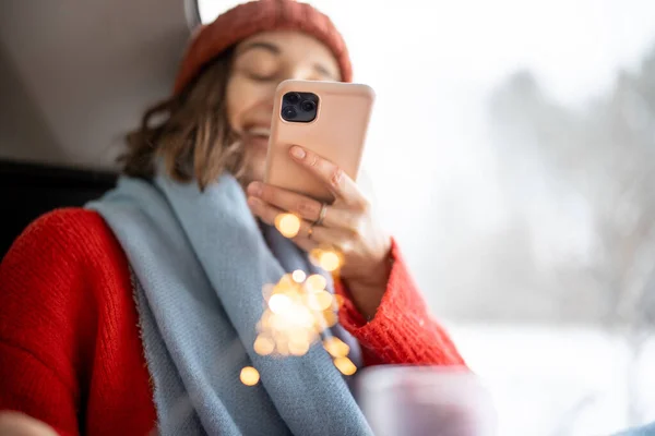 Femme prenant une photo s de scintillant dans sa main tout en étant assis dans le coffre de la voiture — Photo