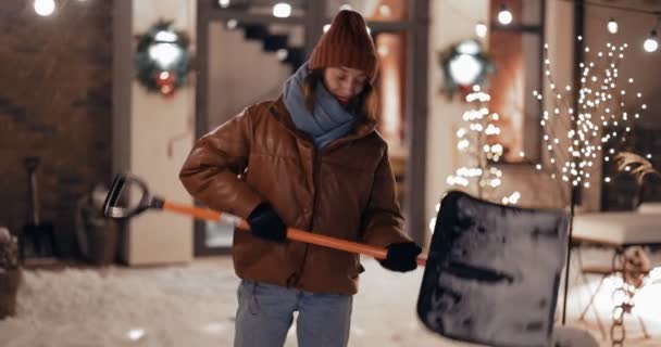 Portret van een enthousiaste vrouw met een sneeuwschop buiten — Stockvideo