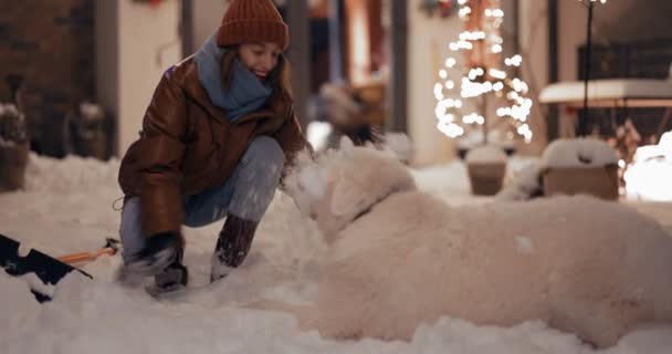 Kışın bahçede köpeğiyle oynayan bir kadın. — Stok video