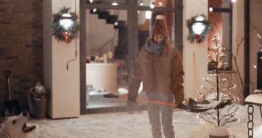 Dışarıda kar küreği taşıyan hevesli bir kadının portresi.