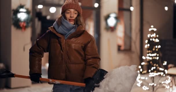 Portrait of enthusiastic woman with a snow shovel outdoors — Stock Video