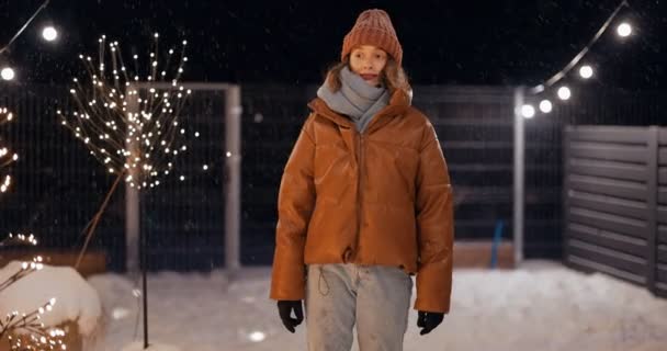 Porträtt av ung kvinna på bakgården av hennes hus på vintersemester — Stockvideo
