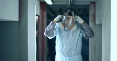 Ressam koruyucu maskesini çıkarıyor.