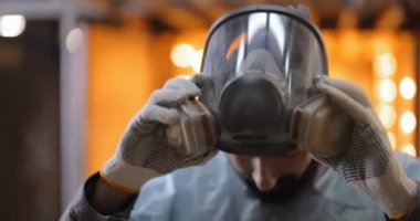 Ressam koruyucu maskesini çıkarıyor.